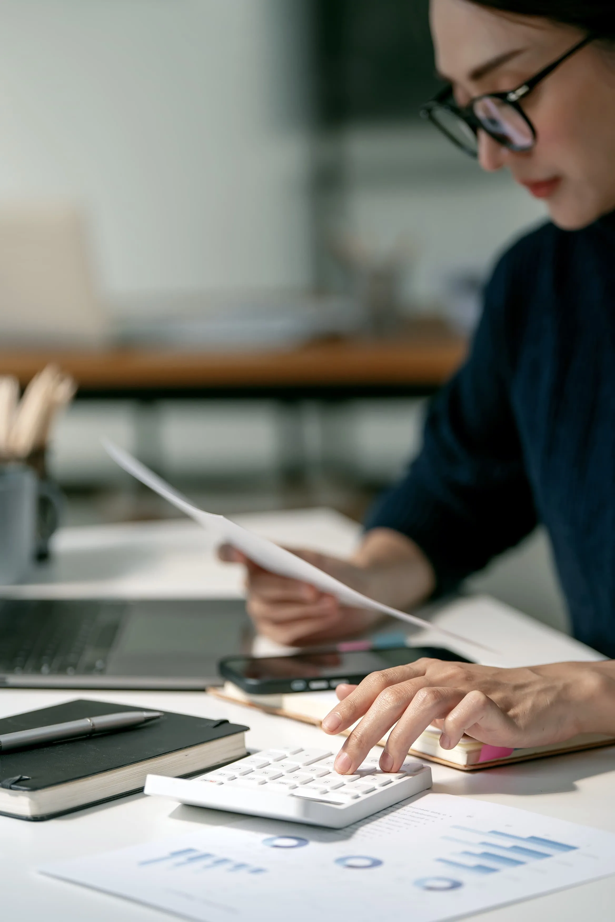 Imagen de una persona con una calculadora haciendo cálculos de cuentas.